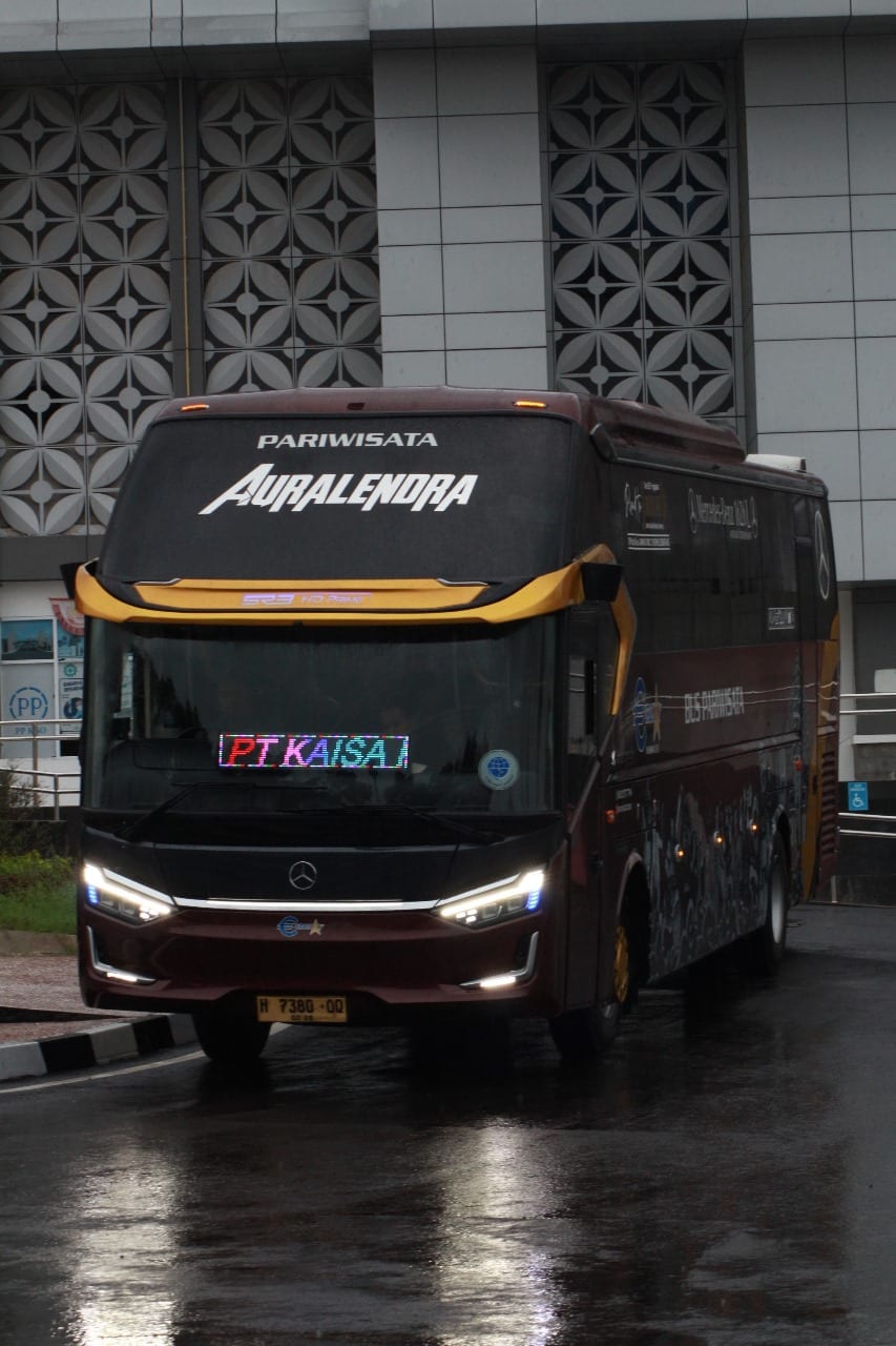 Tampak depan bus Auralendra berwarna marun dengan aksen emas dan tulisan Auralendra pada kaca atas