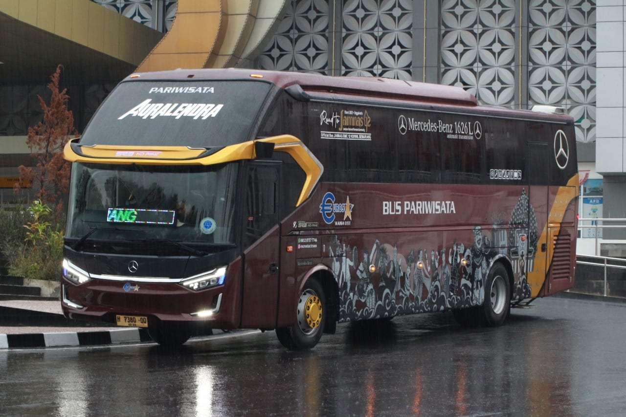 Bus Auralendra bertuliskan Auralendra dengan ilustrasi budaya pada badan bus, tampak samping depan